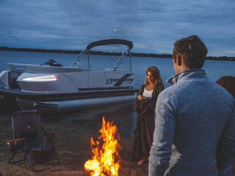 Couple enjoying fire on the beach with 2021 Escape Larson Escape Cruze docked in background